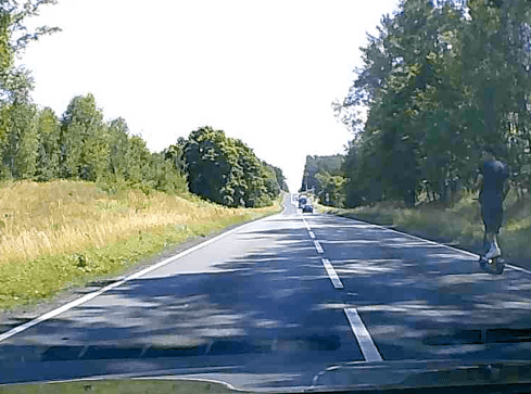 Hulajnoga, chłopak i pies. Szybka jazda po krajówce między tirami - grafika