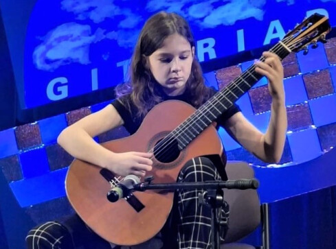 Gitarzystka z pilskiej szkoły muzycznej na podium  - grafika